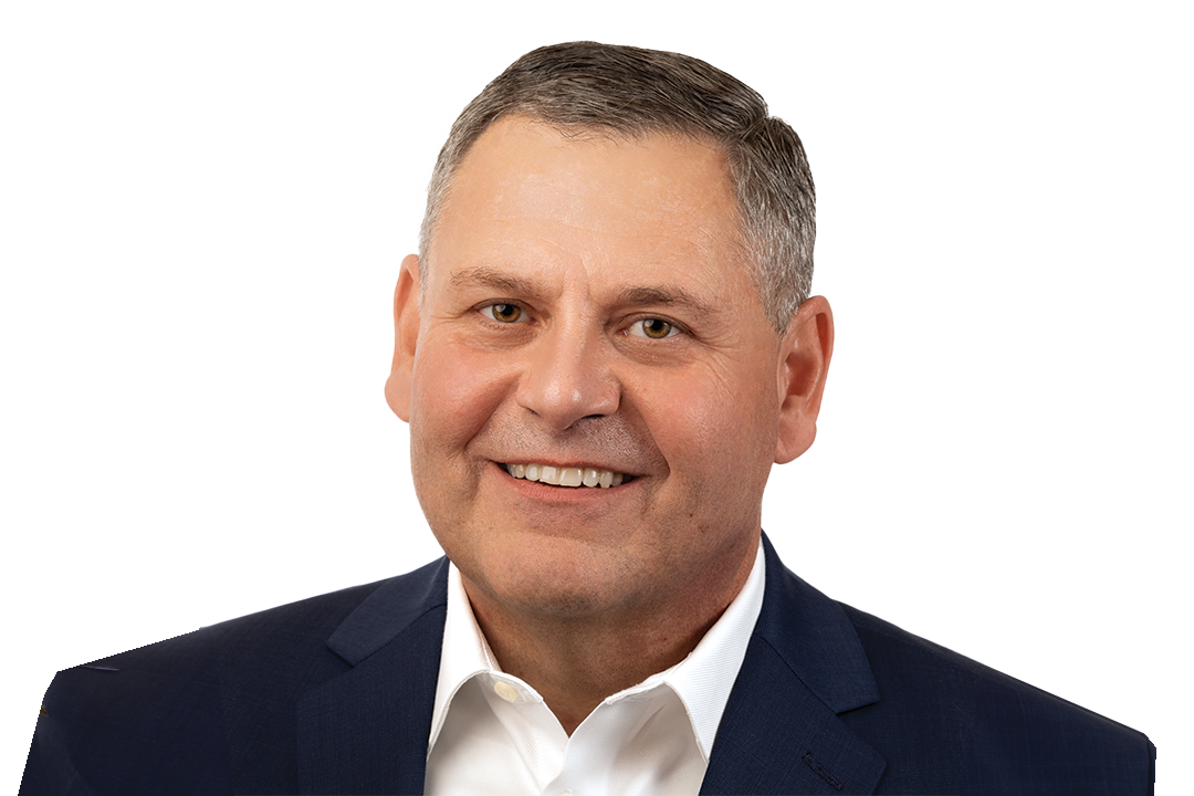 Businessman in a navy suit smiling against a white background